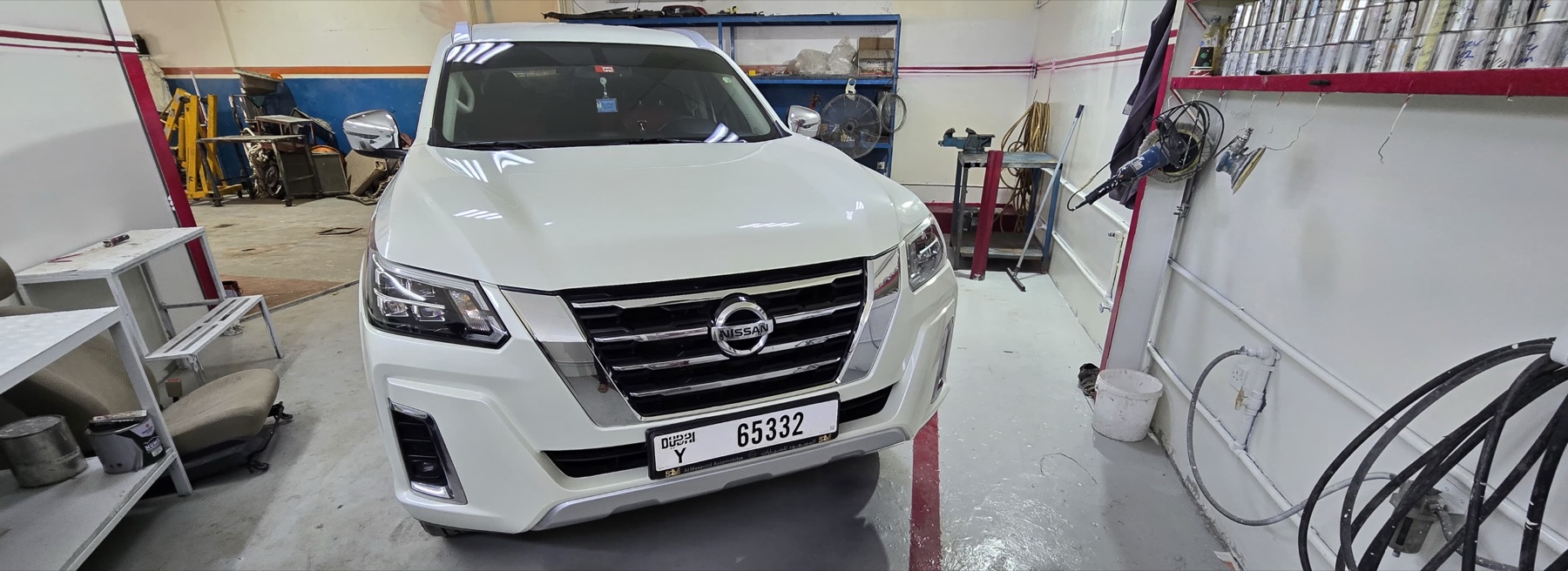 White SUV inside the Al Bedaya Garage workshop ready for inspection